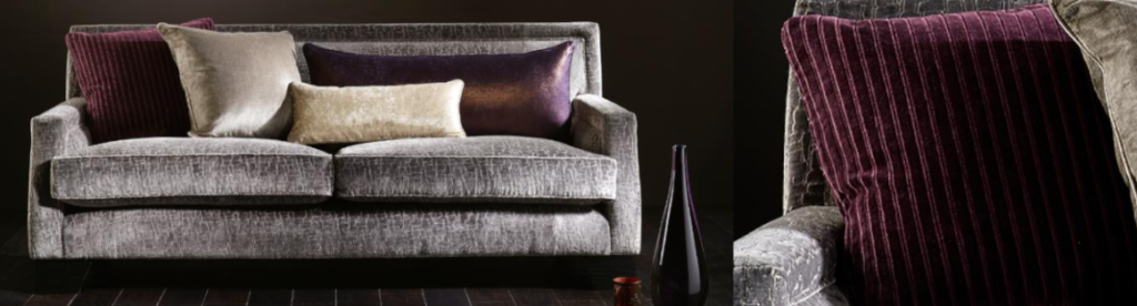 A Sofa shown in a Grey color, and a selction of cushions made from cream and purple fabric from the Wemyss Galileo fabric range